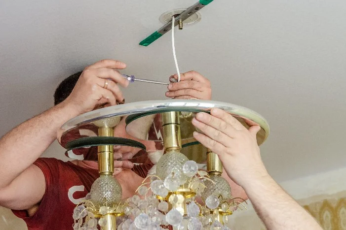 Person montiert Lampe an Decke